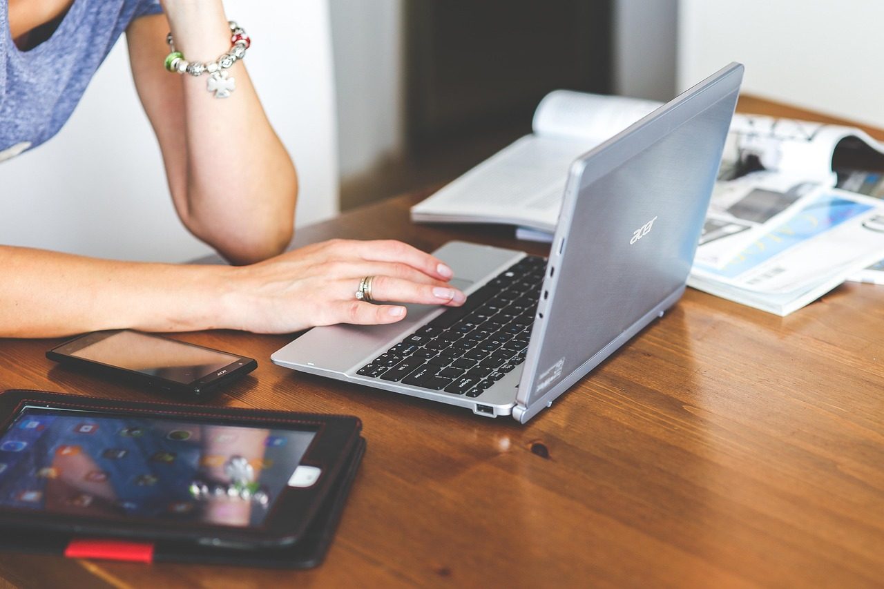 A desk with a laptop, phone, and tablet taking in customer inquiries