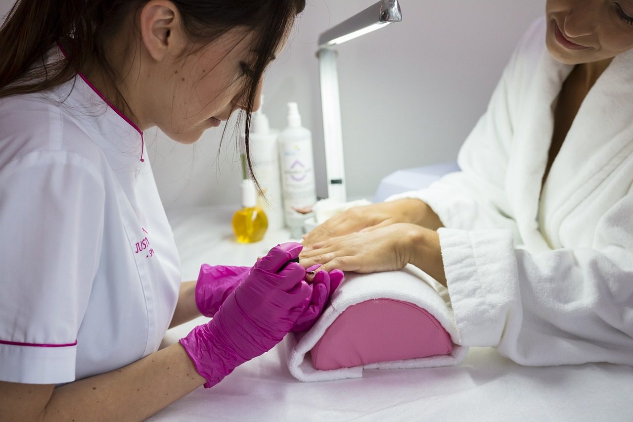 A nail technician giving a client a manicure in a salon